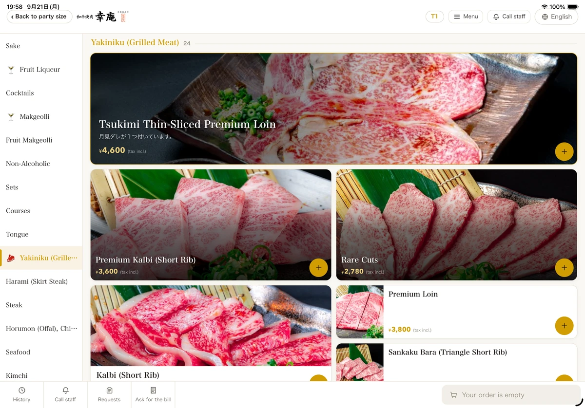 ZEUSの実際の画面：英語表示の卓上タブレット。カテゴリ・商品名・注文ボタンを英語で表示しています。